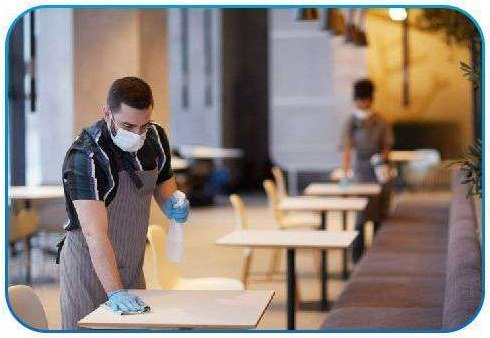 Staff sanitizing tables in an educational institution